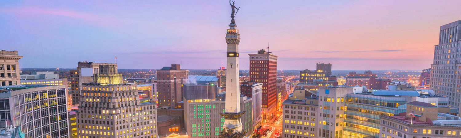 Indianapolis skyline at dusk with the Soldiers and Sailors Monument in downtown traffic circle.