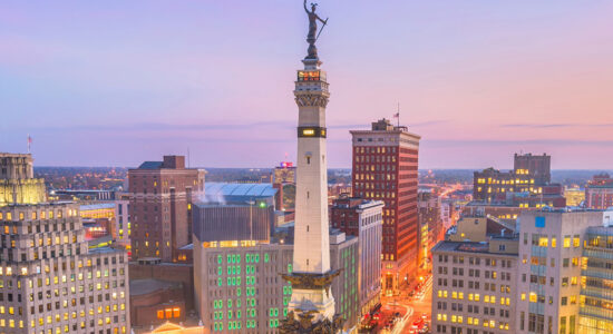 Indianapolis skyline at dusk with the Soldiers and Sailors Monument in downtown traffic circle.