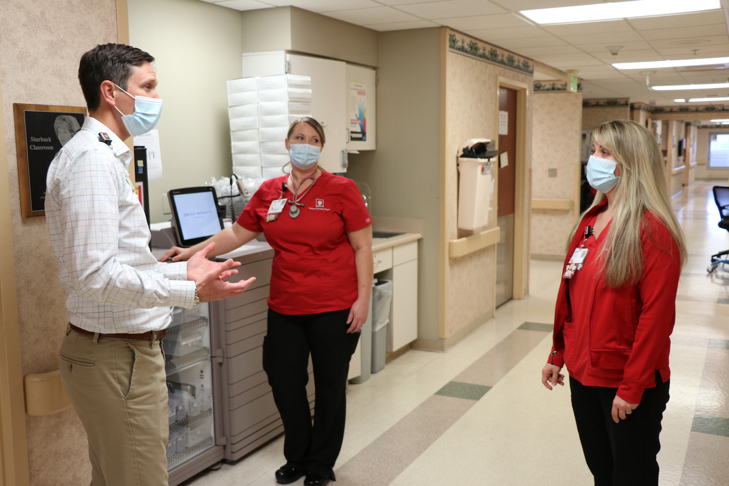 Healthcare workers converse in the hallway