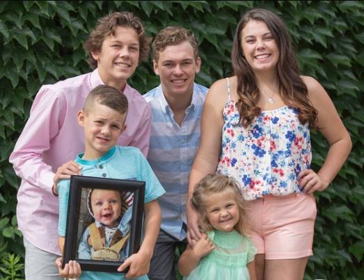 Hittle's family holds up a photo of Brenton