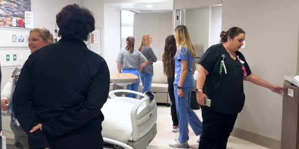 Team members move through mockup of new hospital space image.