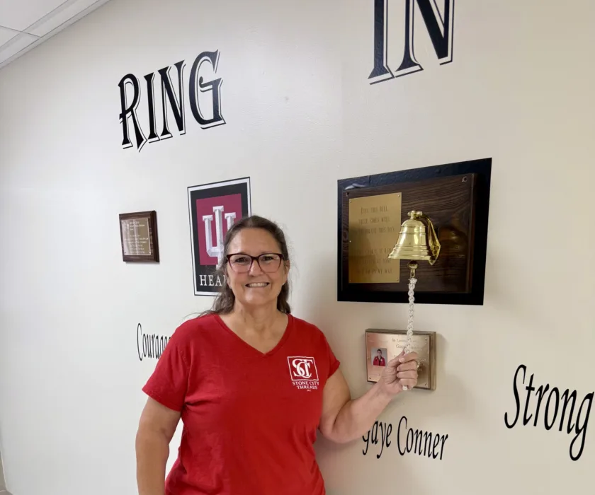 Tina Taylor ringing the bell at IU Health Bedford Hospital after completing her radiation treatment for breast cancer.